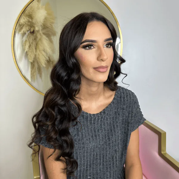 Client with long curled hair and soft makeup